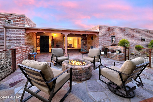 patio terrace at dusk featuring an outdoor living space with a fire pit