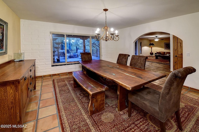 dining room featuring an inviting chandelier, tile patterned floors, and arched walkways