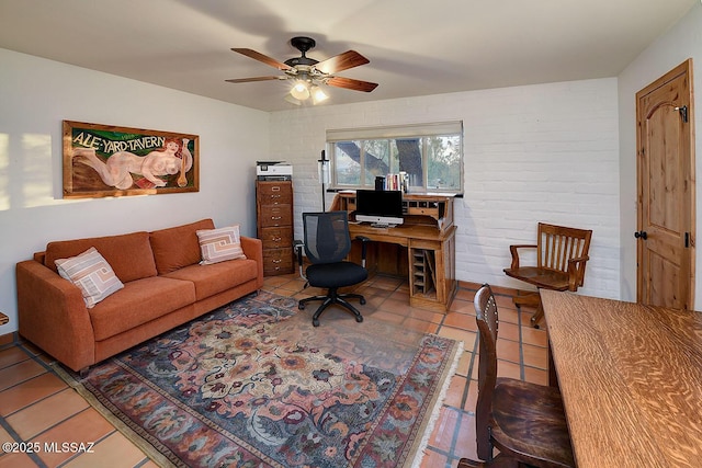 office featuring tile patterned flooring, brick wall, and a ceiling fan