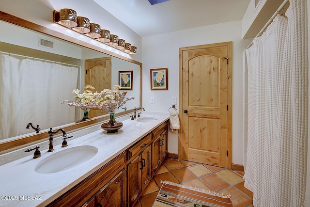 full bathroom featuring tile patterned floors, visible vents, double vanity, and a sink