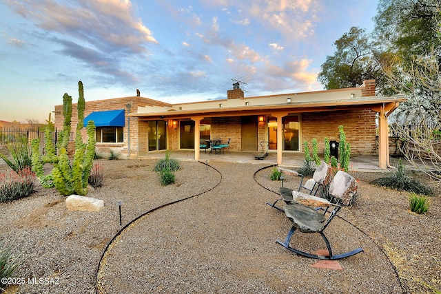 rear view of house featuring a chimney, fence, and a patio area