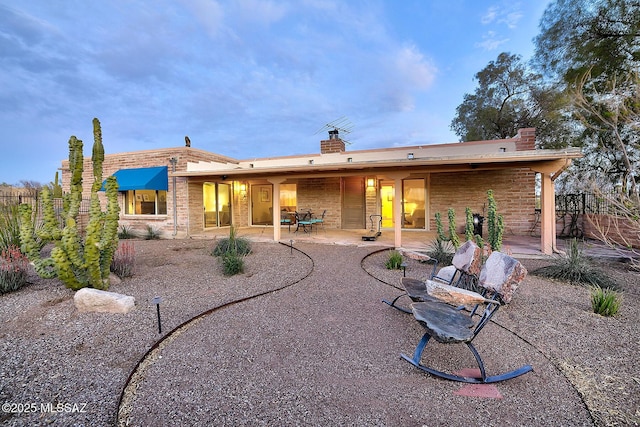 rear view of house with fence, a patio area, and a chimney