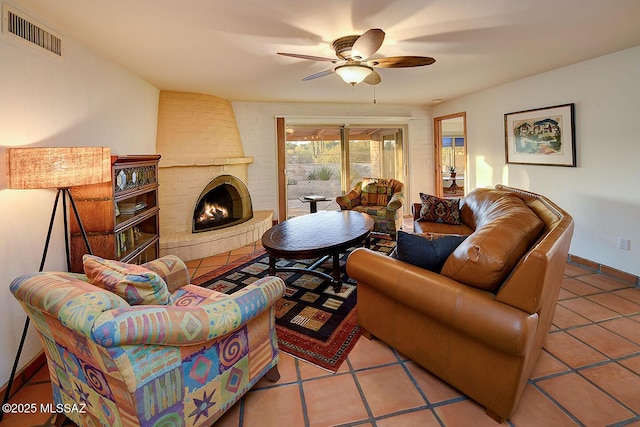 living room with a fireplace, tile patterned floors, ceiling fan, and visible vents