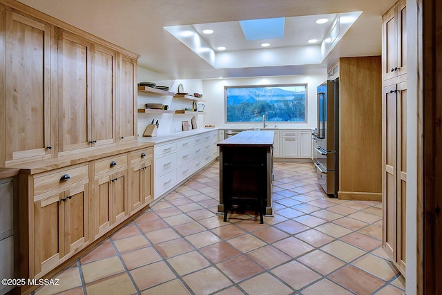 kitchen with light tile patterned flooring, light countertops, open shelves, and high end refrigerator