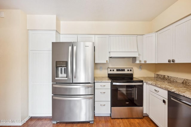 kitchen featuring white cabinets, light wood-style flooring, custom exhaust hood, and stainless steel appliances