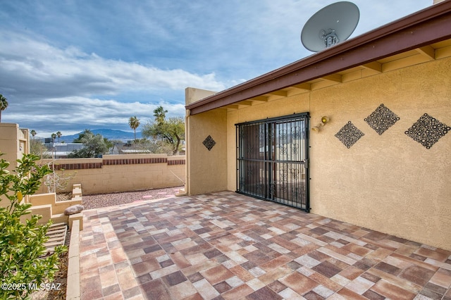 view of patio with fence and a mountain view