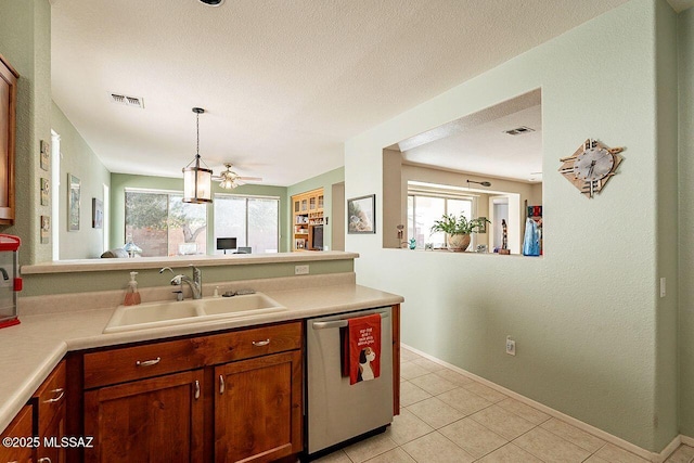 kitchen featuring a wealth of natural light, visible vents, dishwasher, and a sink