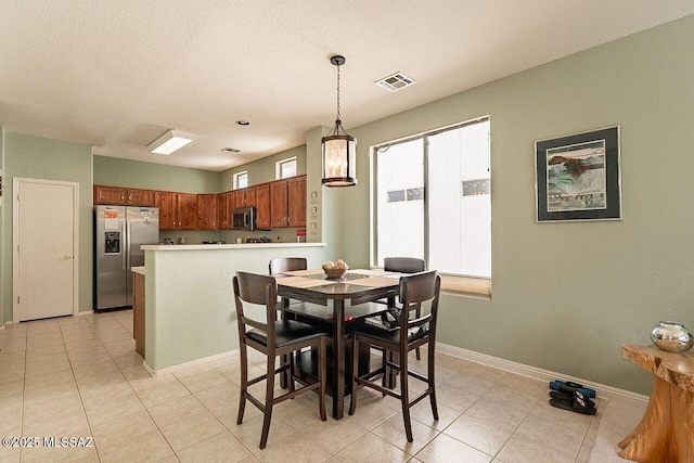 dining area with baseboards, visible vents, a textured ceiling, and light tile patterned flooring