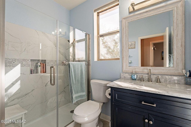 full bath with toilet, a marble finish shower, and vanity