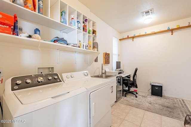 laundry area with light tile patterned floors, a sink, visible vents, independent washer and dryer, and cabinet space