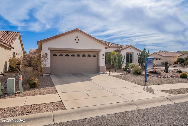 mediterranean / spanish-style house with driveway, an attached garage, a tile roof, and stucco siding