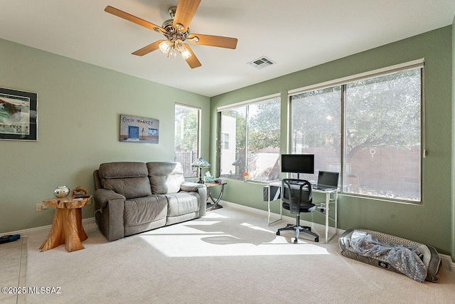 carpeted home office with a ceiling fan, visible vents, and baseboards