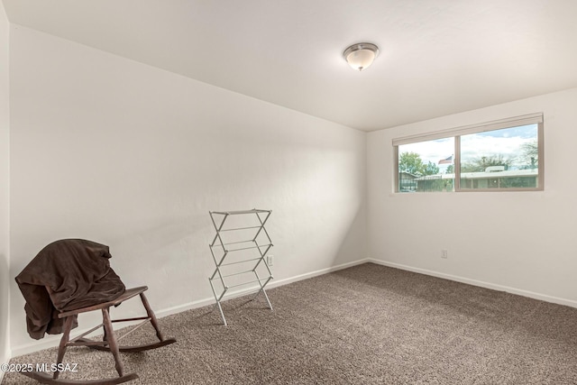 carpeted empty room featuring baseboards