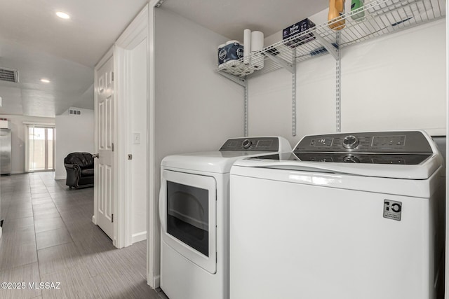 clothes washing area with laundry area, independent washer and dryer, visible vents, and recessed lighting