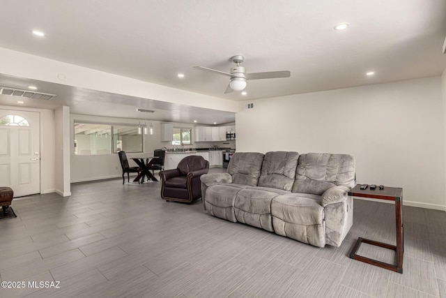 living area with ceiling fan, recessed lighting, visible vents, and baseboards