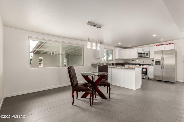 dining room with baseboards, wood finish floors, and recessed lighting