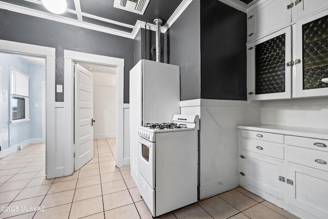 kitchen with light tile patterned floors, light countertops, visible vents, white cabinetry, and white range with gas cooktop