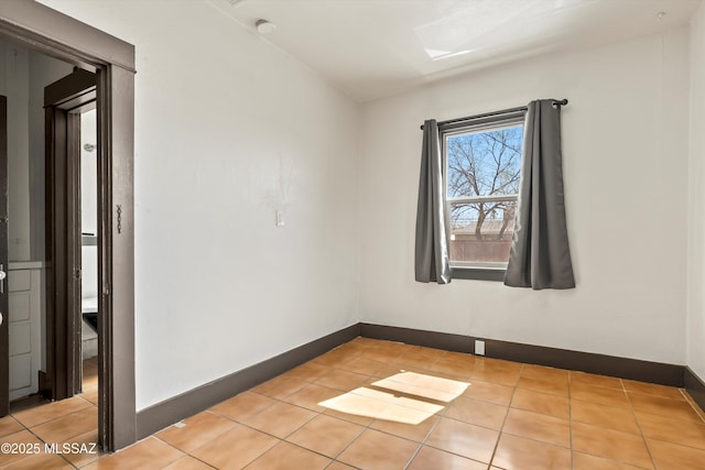 unfurnished room featuring light tile patterned flooring and baseboards