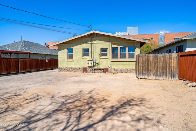 back of house with fence and stucco siding