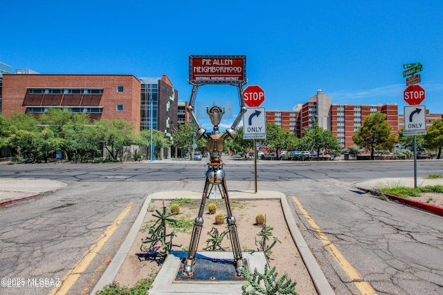 view of road featuring sidewalks, traffic signs, and curbs