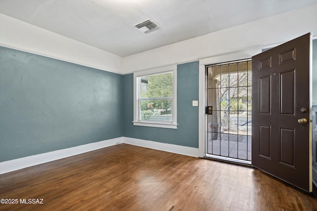 interior space featuring hardwood / wood-style floors, visible vents, and baseboards