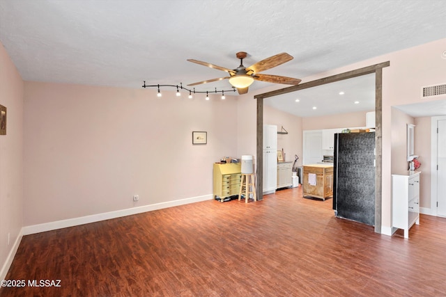 unfurnished living room with baseboards, wood finished floors, visible vents, and ceiling fan