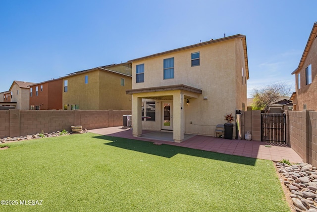 back of house featuring central AC, a fenced backyard, stucco siding, a yard, and a patio area