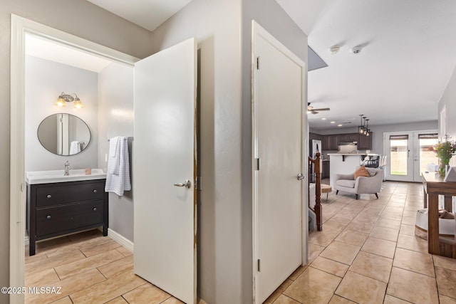 hallway with baseboards and a sink