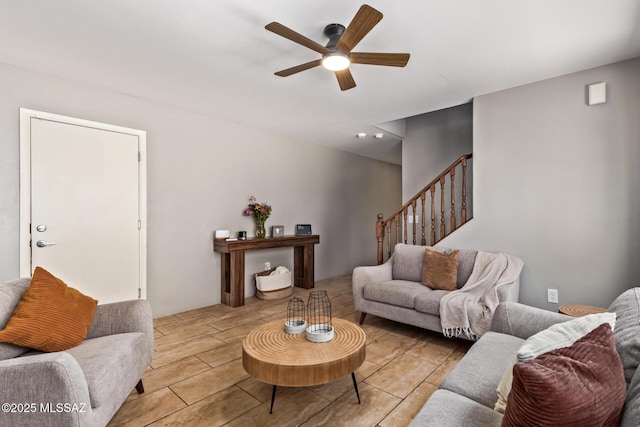 living area featuring a ceiling fan and stairway