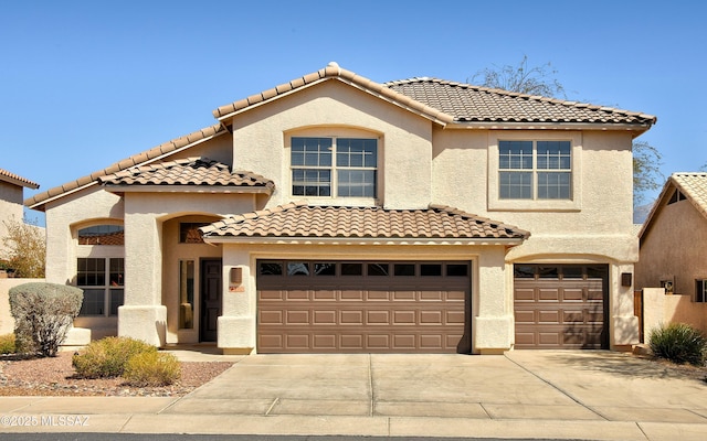 mediterranean / spanish home featuring driveway, an attached garage, and stucco siding