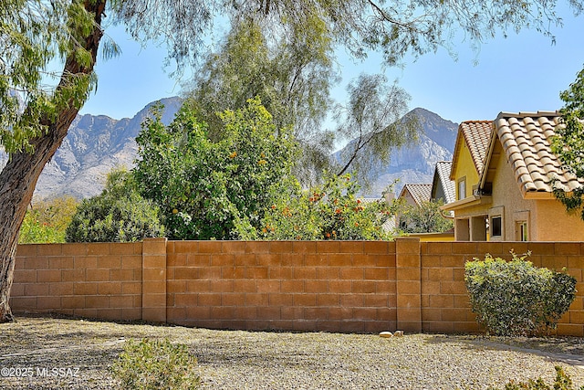 view of yard featuring fence and a mountain view