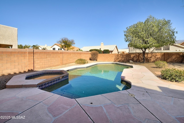 view of pool featuring a patio area, a fenced backyard, and a pool with connected hot tub