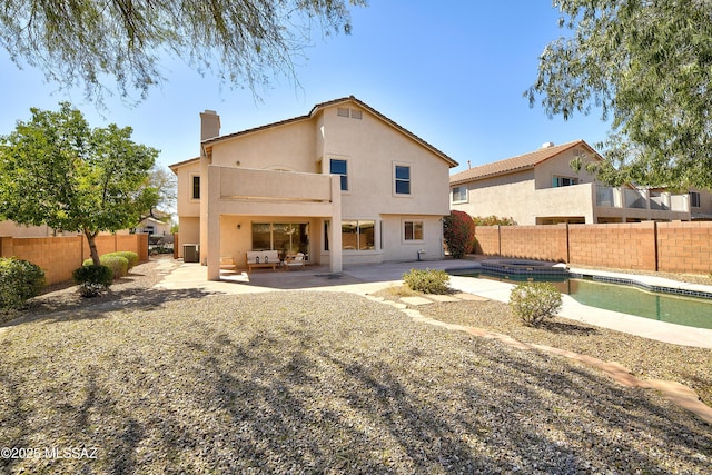 rear view of house with a patio, a fenced backyard, and stucco siding