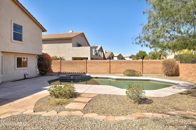 view of pool featuring a patio area, a fenced backyard, and a pool with connected hot tub