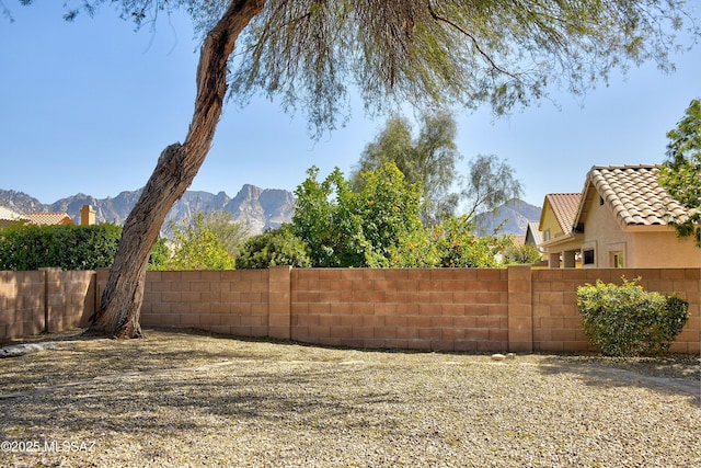 view of yard featuring fence and a mountain view