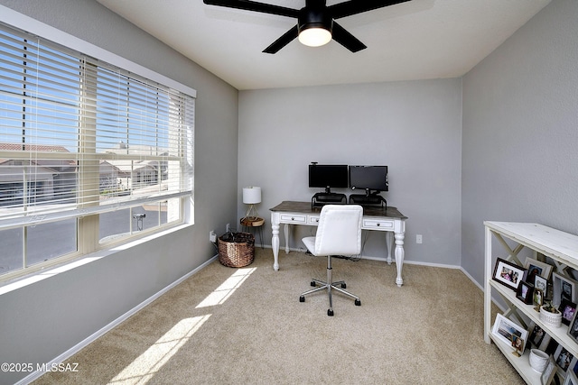 carpeted office with ceiling fan and baseboards