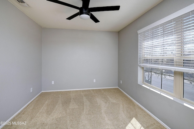 empty room featuring carpet floors, baseboards, visible vents, and a ceiling fan