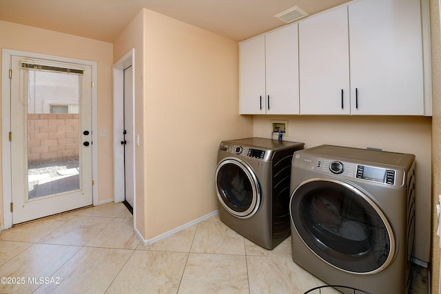 laundry area with light tile patterned floors, visible vents, baseboards, independent washer and dryer, and cabinet space