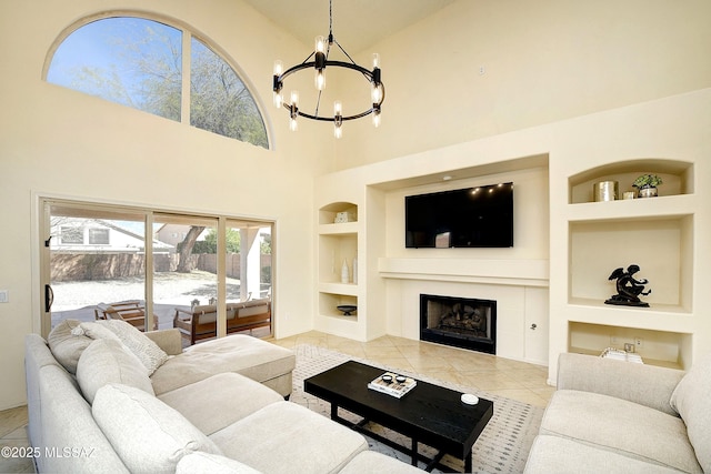 living room with built in shelves, a chandelier, a fireplace, and tile patterned floors