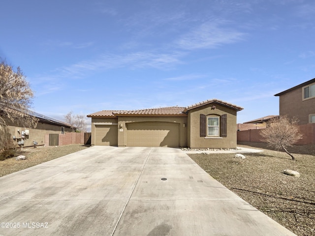 mediterranean / spanish house with fence, driveway, an attached garage, and stucco siding