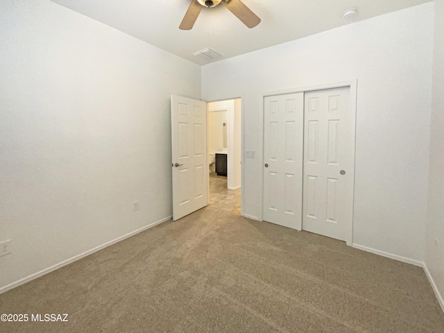 unfurnished bedroom featuring baseboards, ceiling fan, a closet, and light colored carpet