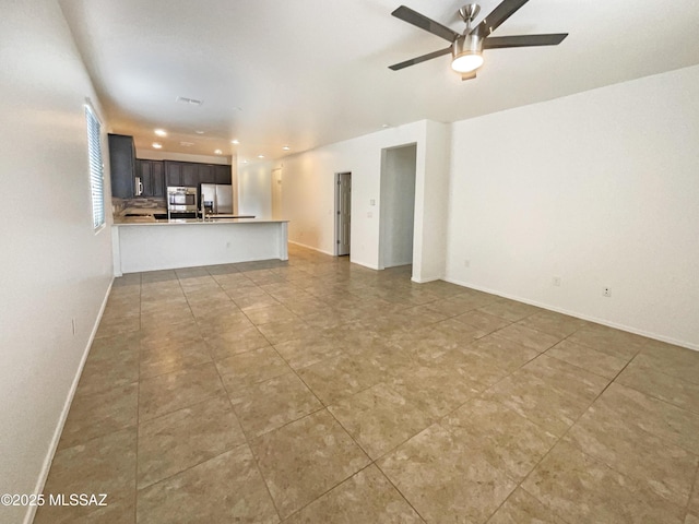 unfurnished living room featuring ceiling fan, baseboards, and recessed lighting