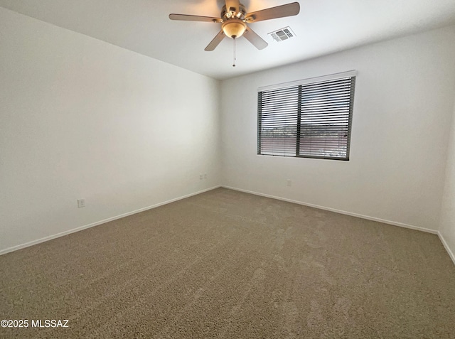 carpeted spare room featuring ceiling fan, visible vents, and baseboards