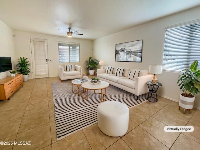 living area featuring a ceiling fan, baseboards, and light tile patterned floors