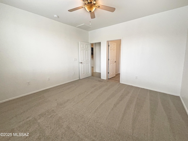 carpeted spare room featuring a ceiling fan and baseboards