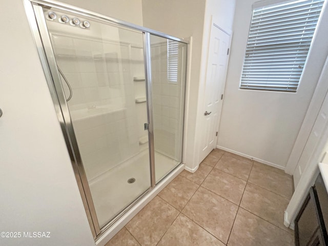 bathroom with tile patterned flooring, vanity, baseboards, and a shower stall