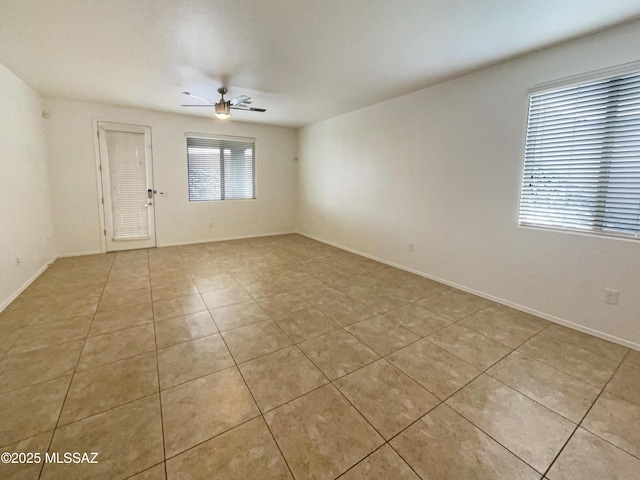 spare room with a ceiling fan and light tile patterned floors