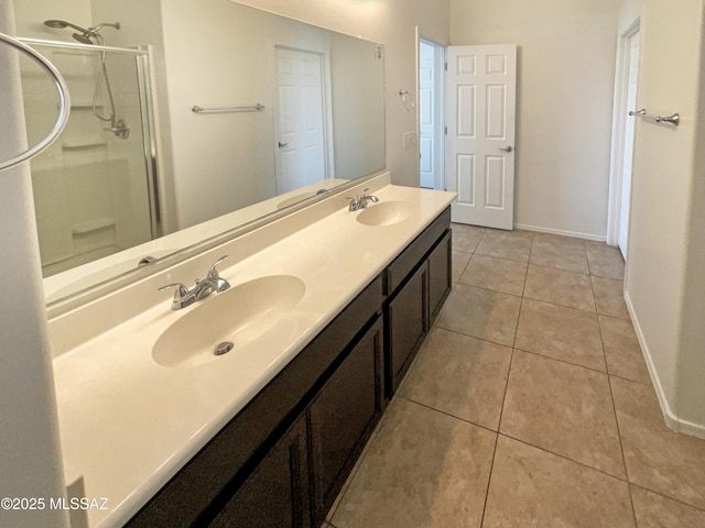 bathroom with double vanity, a stall shower, a sink, and tile patterned floors