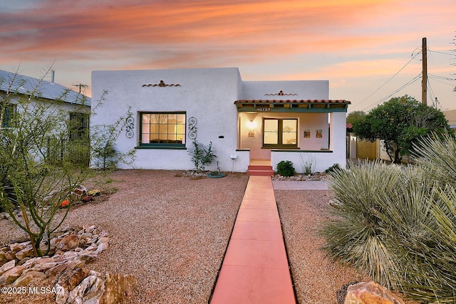 mediterranean / spanish-style home featuring a tiled roof and stucco siding