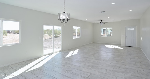 interior space with baseboards, ceiling fan with notable chandelier, visible vents, and recessed lighting